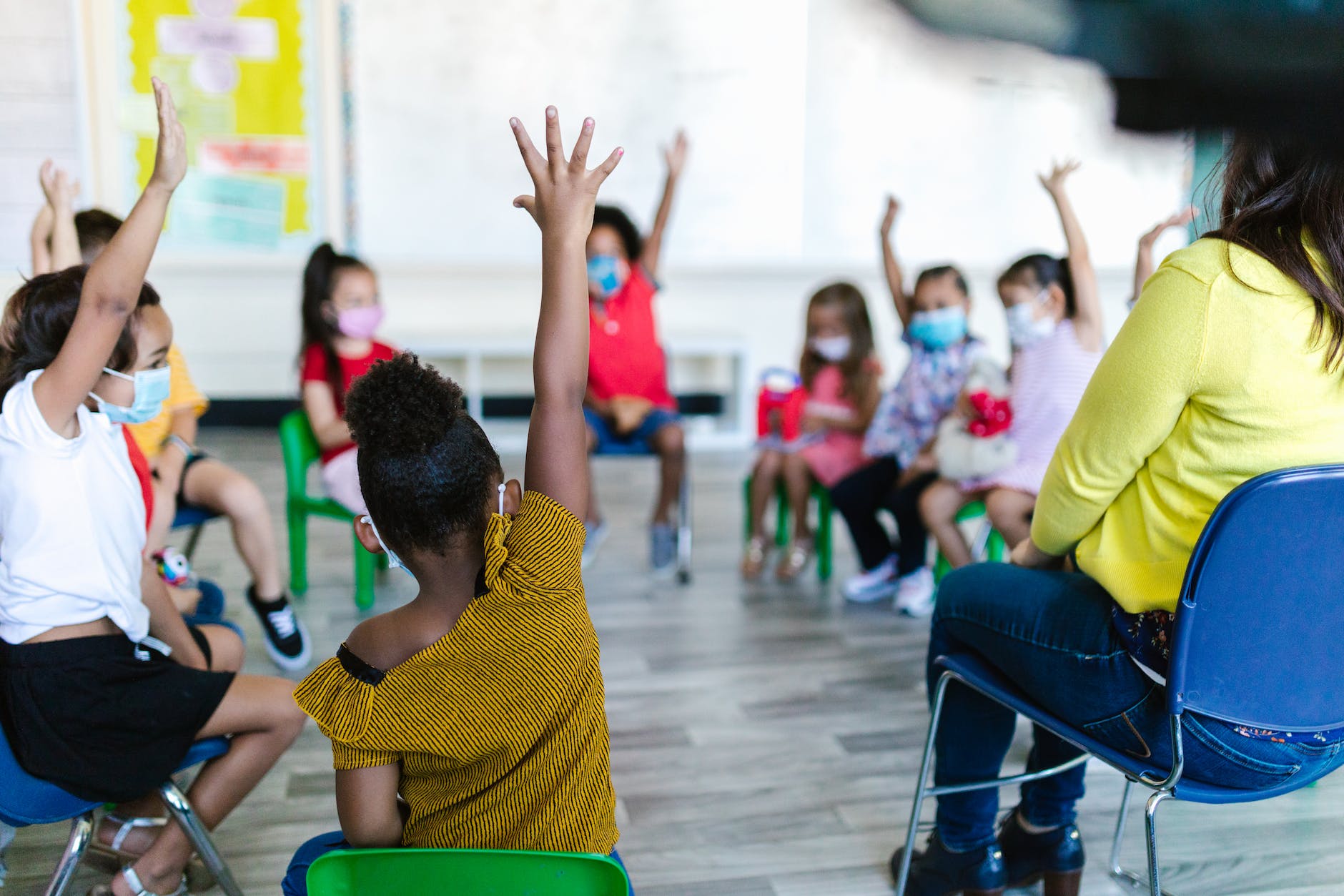 lids raising their hands in the classroom