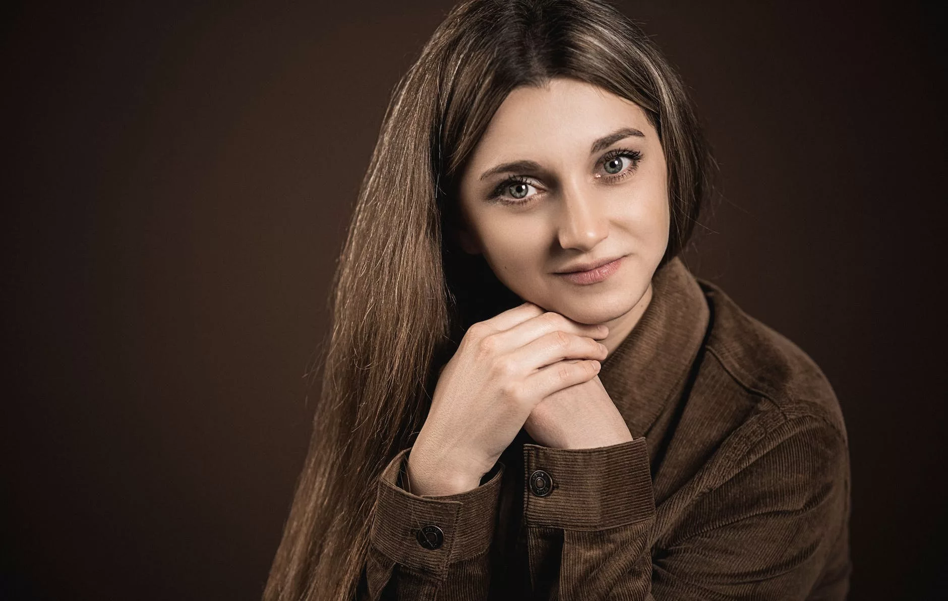 crop woman with long silky hair on brown background