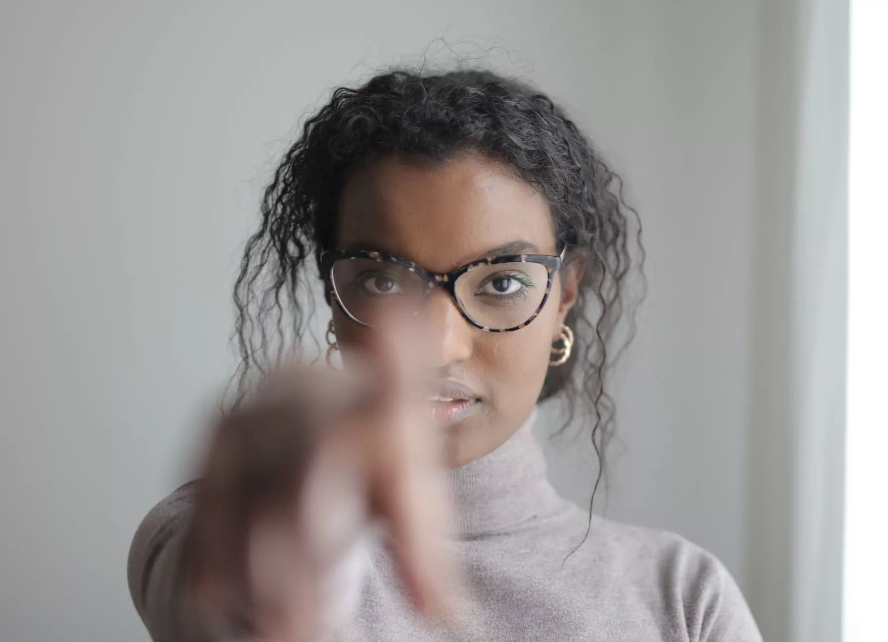 young ethnic woman pointing at camera